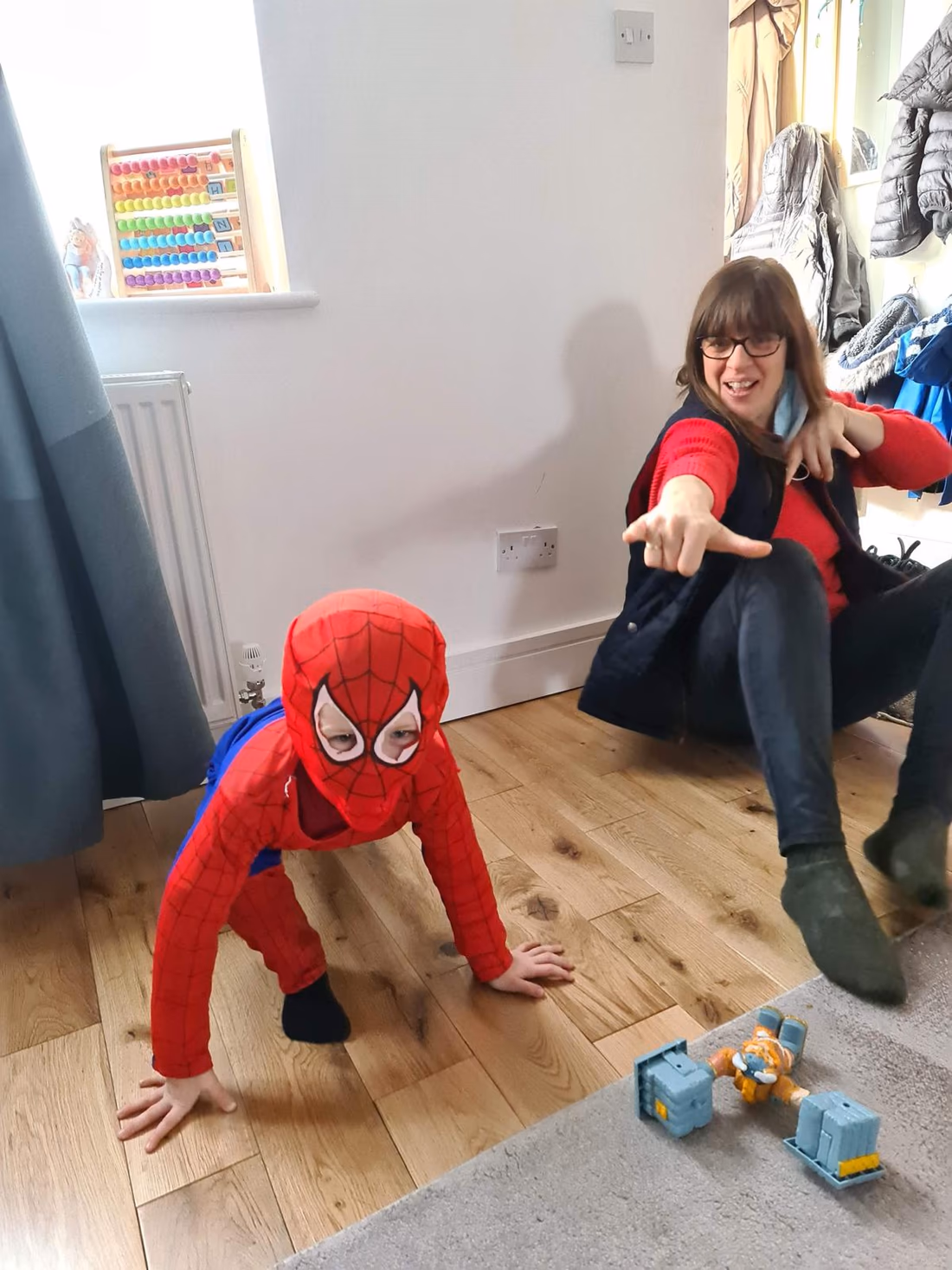 Anna joining a child in superhero play during a speech and language therapy session.